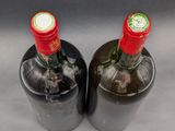 two bottles of wine sitting next to each other on a table
