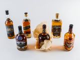 several bottles of alcohol are lined up on a white surface