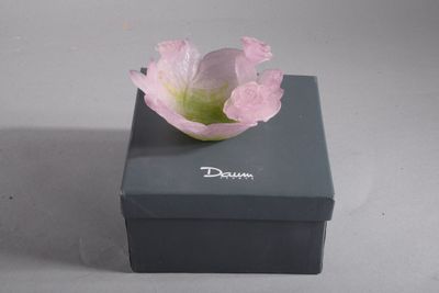 une fleur rose posée sur une boîte noire
