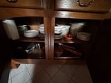 de nombreuses assiettes et casseroles empilées sur une étagère dans la cuisine