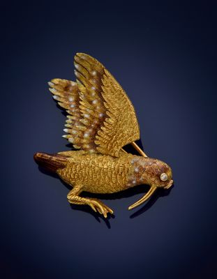 an image of a gold bird broochle on a black background
