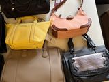 many different purses on a table in a room