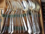 a lot of silver spoons and forks in a box