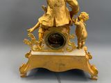 a gold clock with a man and a child on it