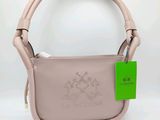 un gros plan sur un sac à main rose orné d'une étiquette verte