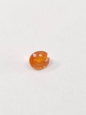 un gros plan d'un saphir orange sur une surface blanche
