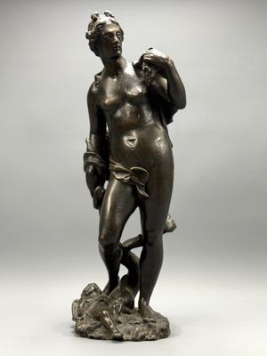 a bronze statue of a man holding a bird on a rock