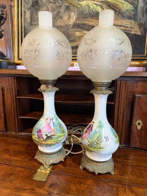 deux lampes posées sur une table devant un tableau