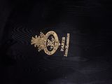 the back of a black jacket with a gold emblem on it