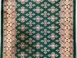 a green rug with a gold border on a white background