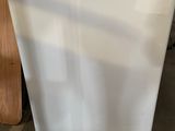 a white refrigerator sitting on the floor in a room