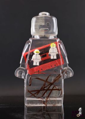 un bonhomme Lego qui tient une valise rouge et noire
