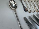 a lot of silver spoons and forks on the table