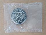 une médaille d'argent posée sur un sac en plastique posé sur une table