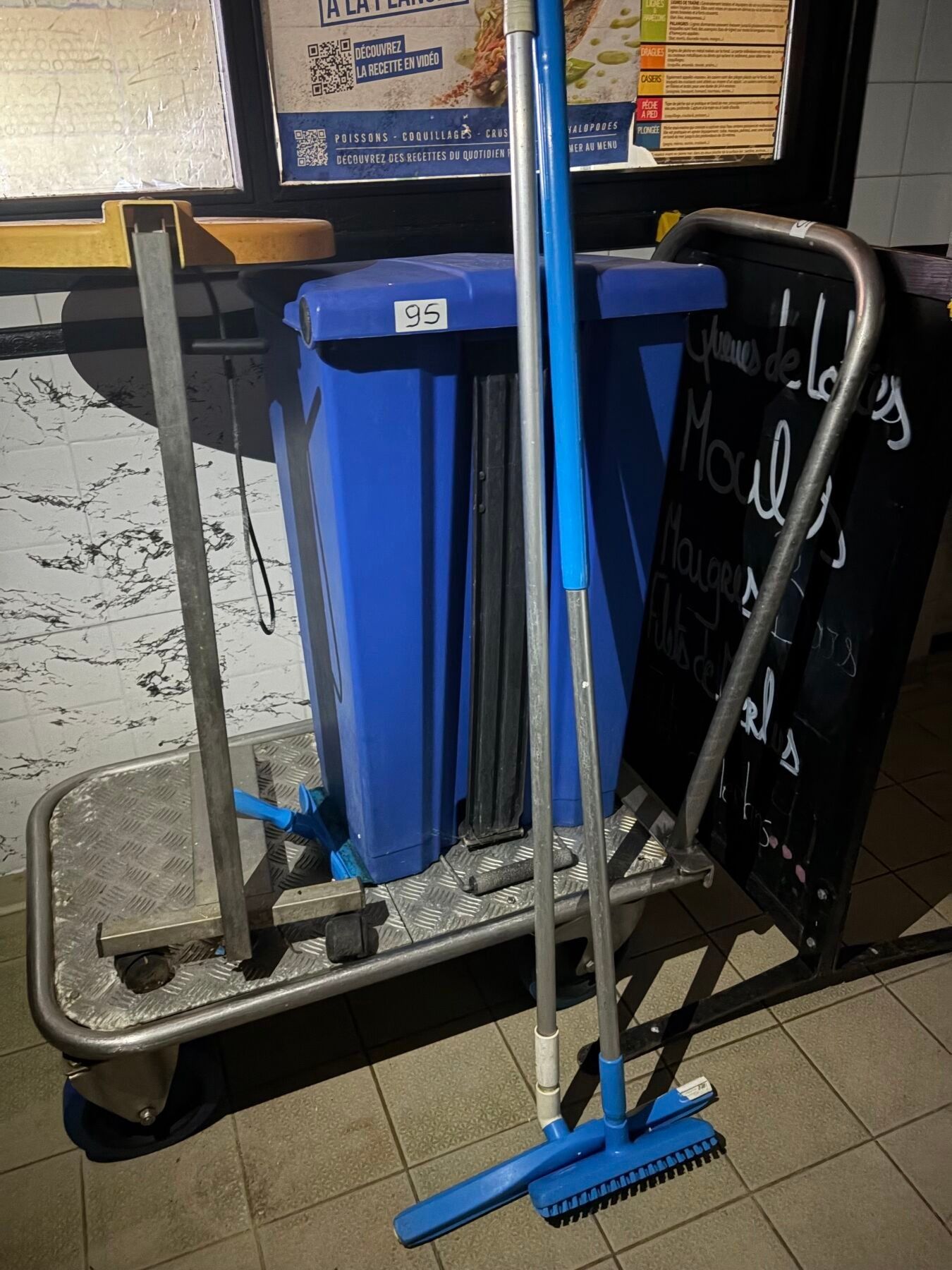 Un chariot à bras. On y joint deux poubelles et un panneau d…