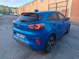 the rear end of a blue car parked in a parking lot