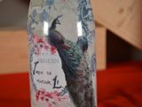 a bottle with a peacock on it sitting on a table
