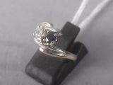 une bague en argent sertie d'un diamant bleu, montée sur un morceau de cuir noir