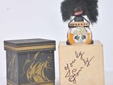 a small stuffed animal sitting on a box next to a box