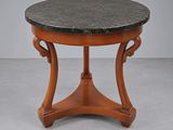 une table avec un plateau en marbre noir, des pieds en bois et un piètement en bois