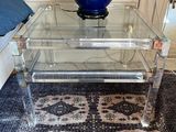 a glass table with a blue vase on top of it