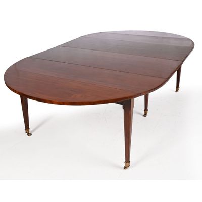 an oval mahogany dining table with four leaves on the legs