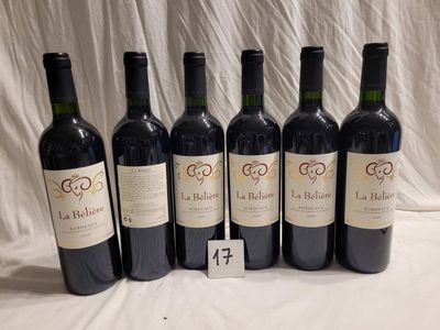six bottles of red wine lined up in a row on a table