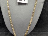 un gros plan d'un collier porté par un mannequin, sur lequel figure un numéro