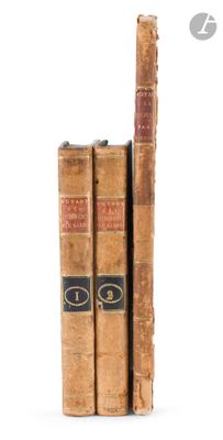 two old books sitting on top of each other on a white surface