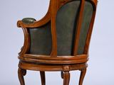 a wooden chair with a green leather seat on a white background