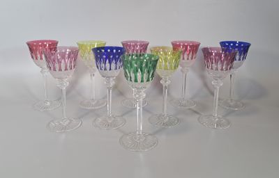 six verres à vin colorés alignés en rang sur une surface blanche