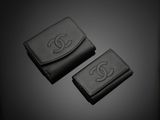 two black leather wallets sitting on top of a black surface