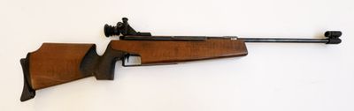 le fusil est posé contre le mur, à côté du mur