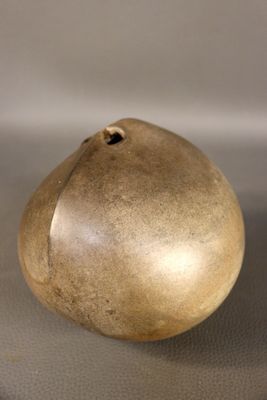 une image représentant un vase de couleur dorée posé sur une table
