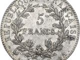 a silver coin with a wreath of leaves on it