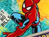 une affiche représentant Spider-Man accroché à la façade d'un immeuble