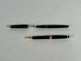 two black and gold pens sitting on top of a white surface