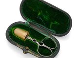 a pair of scissors in a case on a white surface