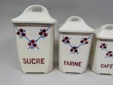 three white containers with red and blue designs on them