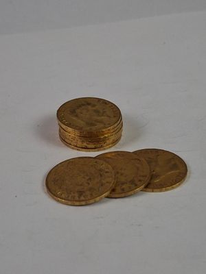 a pile of gold coins sitting on a white surface