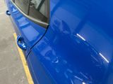a blue car that is parked on the side of the street