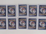 six pokemon trading cards are arranged in a row on a white surface