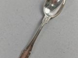 silver spoon with a long handle on a gray surface
