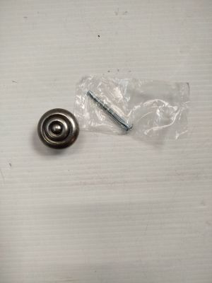une petite bille métallique et une vis posées sur une table