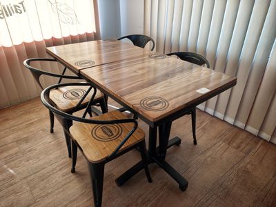 une table en bois entourée de quatre chaises dans une pièce