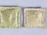 two pieces of cloth with a small bag on top of it