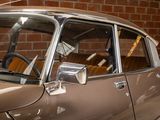 a brown car that is parked in front of a brick wall