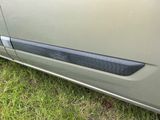 un gros plan sur la poignée de porte d'une voiture posée sur l'herbe