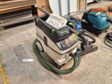 a dust extracter that is sitting on the floor