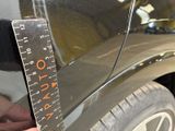 someone is measuring the height of a car with a ruler